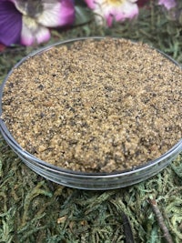 a small bowl of sand on top of some flowers