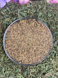 a small bowl of brown sand on a green grass