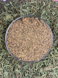 a bowl of brown sand on a green grass
